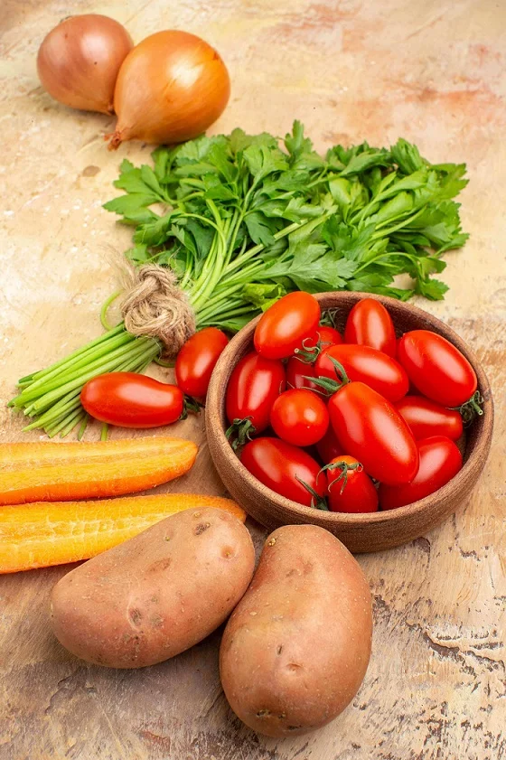 pietruszka, cebula, pomidory, marchewka i ziemniaki estetycznie ułożone 