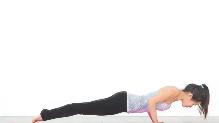 Kobieta wykonująca ćwiczenie plank na macie treningowej
