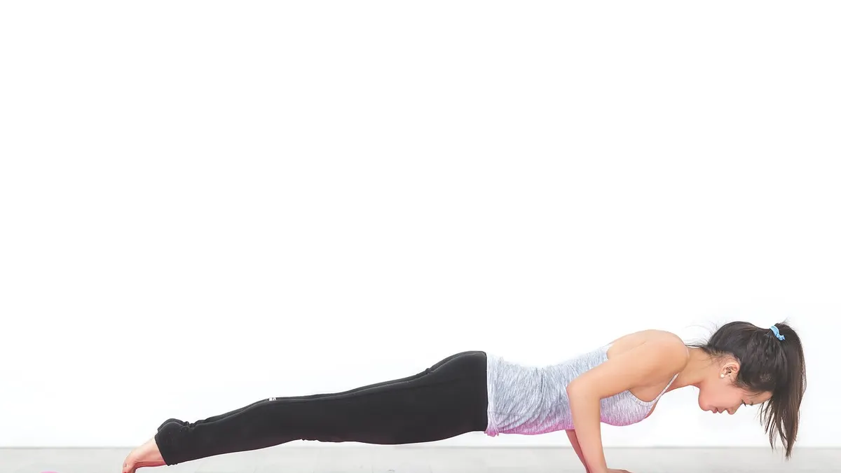 Kobieta wykonująca ćwiczenie plank na macie treningowej