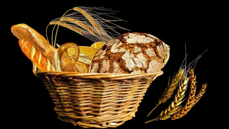 Bułki pszenne i pełnoziarniste na talerzu obok wagi kuchennej