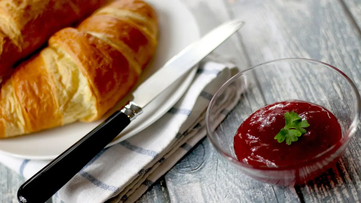 Maślany croissant na talerzu w piekarni
