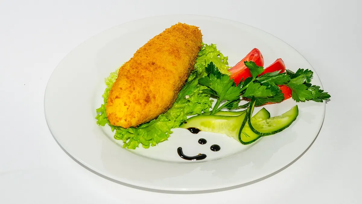 Smażony kotlet mielony na talerzu z dodatkami
