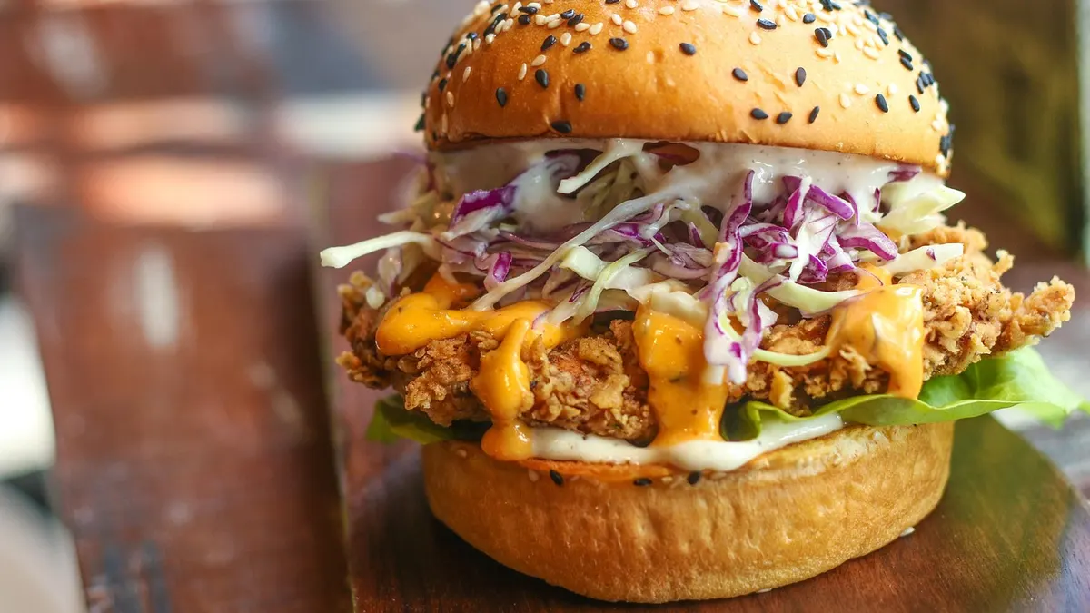 Kanapka z kurczakiem na tacy z frytkami w restauracji fast food