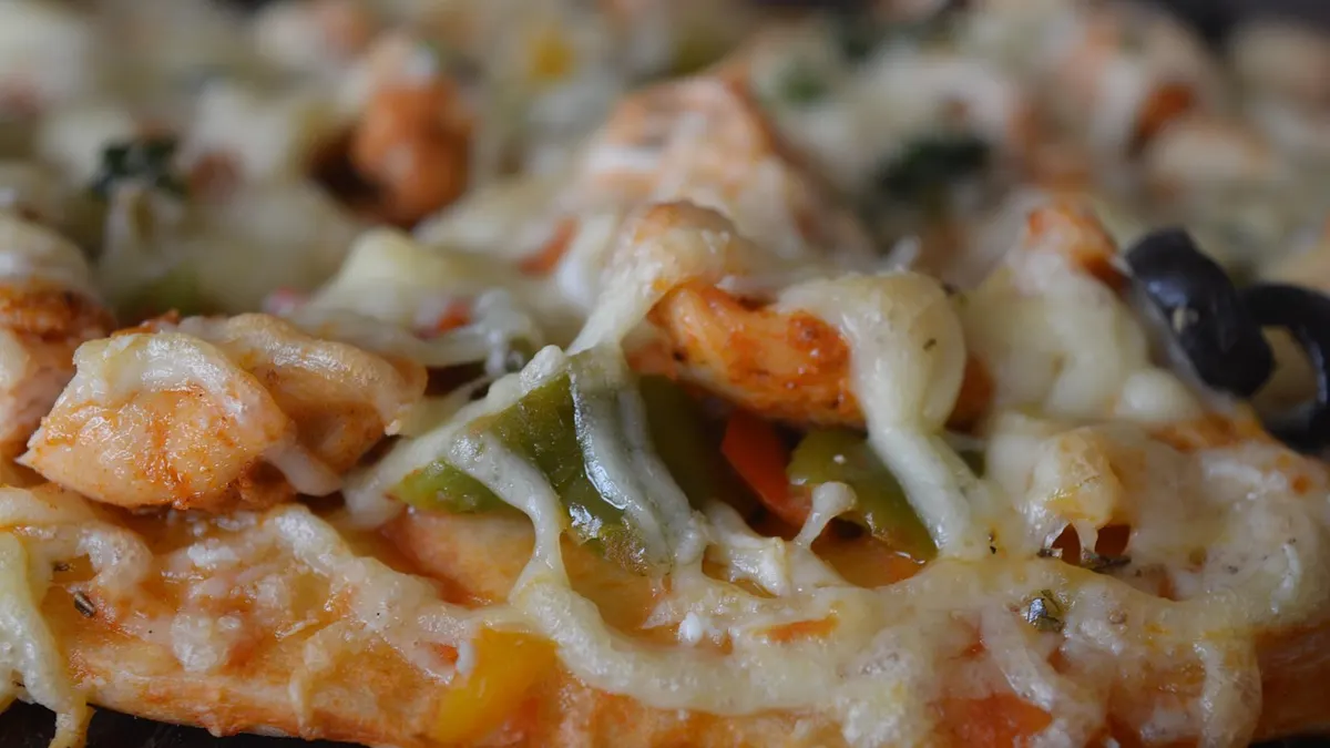 Kawałki pizzy z serem i dodatkami na talerzu
