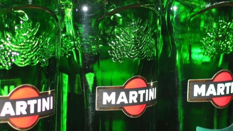 Butelka wódki i kieliszek z czystym alkoholem na stole