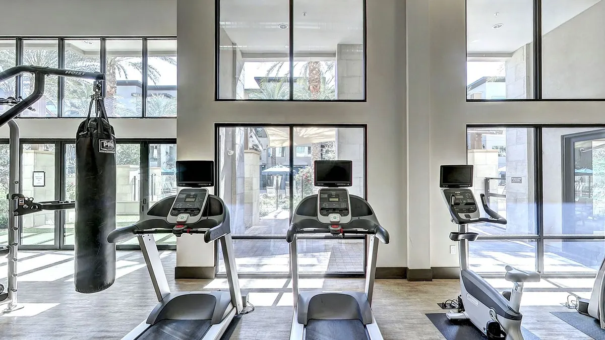 Osoba idąca na bieżni treningowej podczas spokojnego treningu cardio