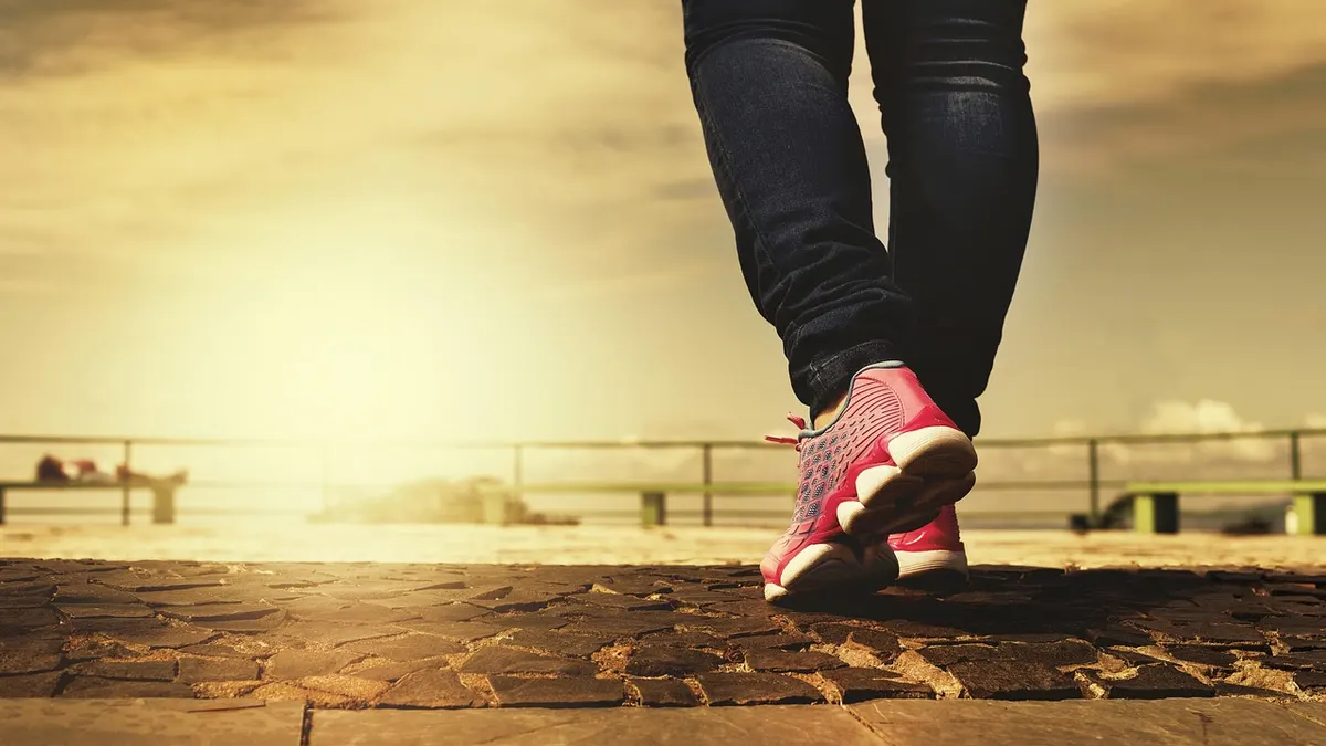 Buty sportowe i zegarek mierzący kroki podczas marszu po parku