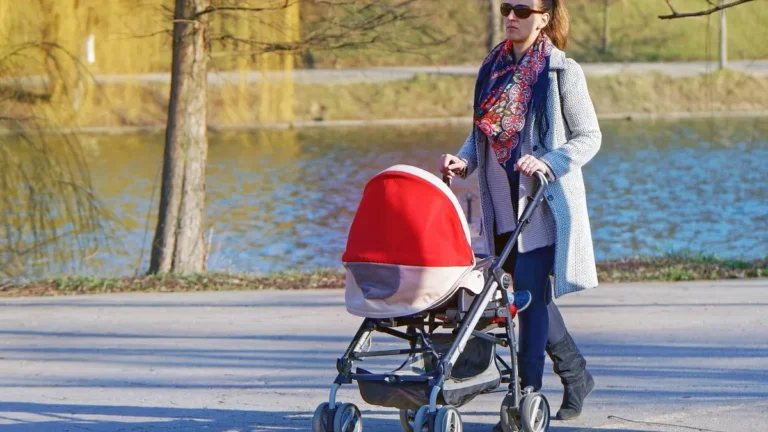 Mama spacerująca z wózkiem po parku jako łagodna aktywność po ciąży