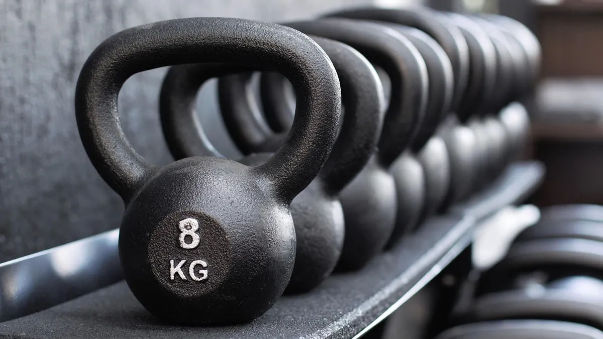 Odważnik kettlebell na podłodze przygotowany do treningu siłowego w domu