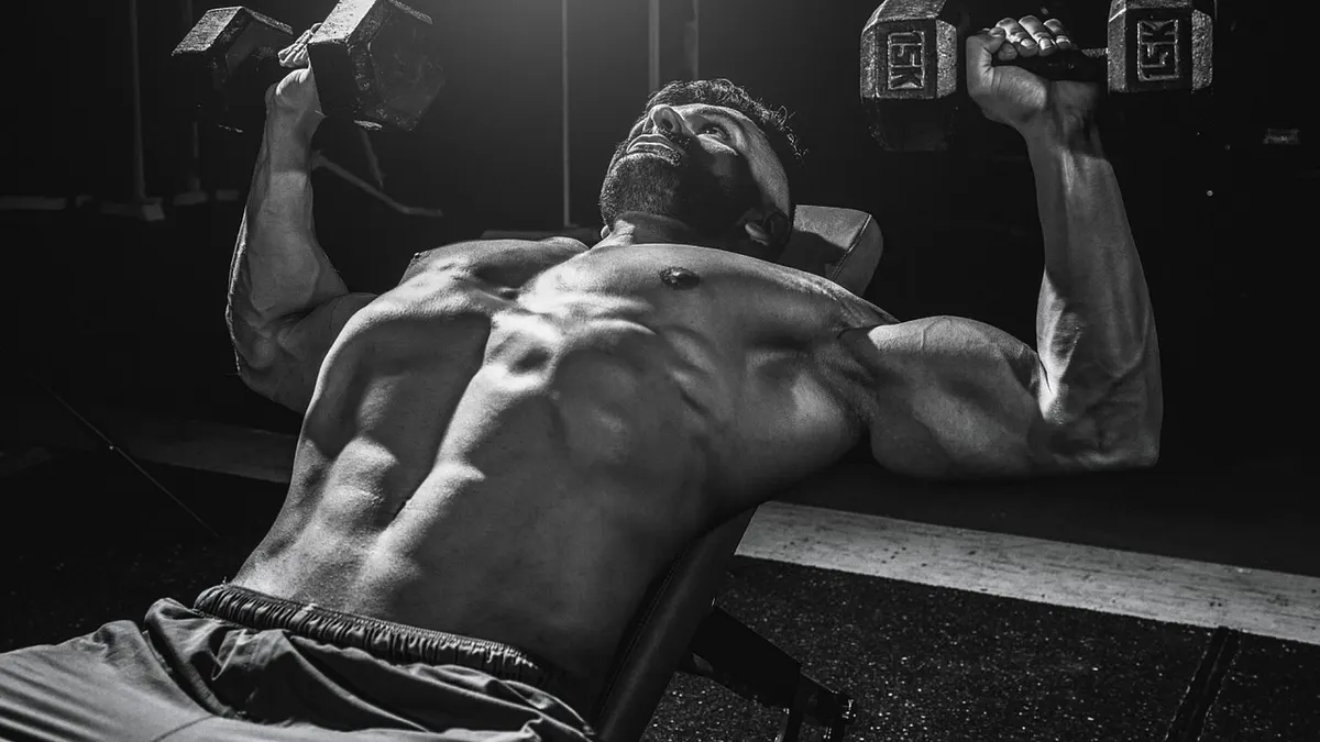 Hantle i sztanga przygotowane do treningu bicepsa na siłowni
